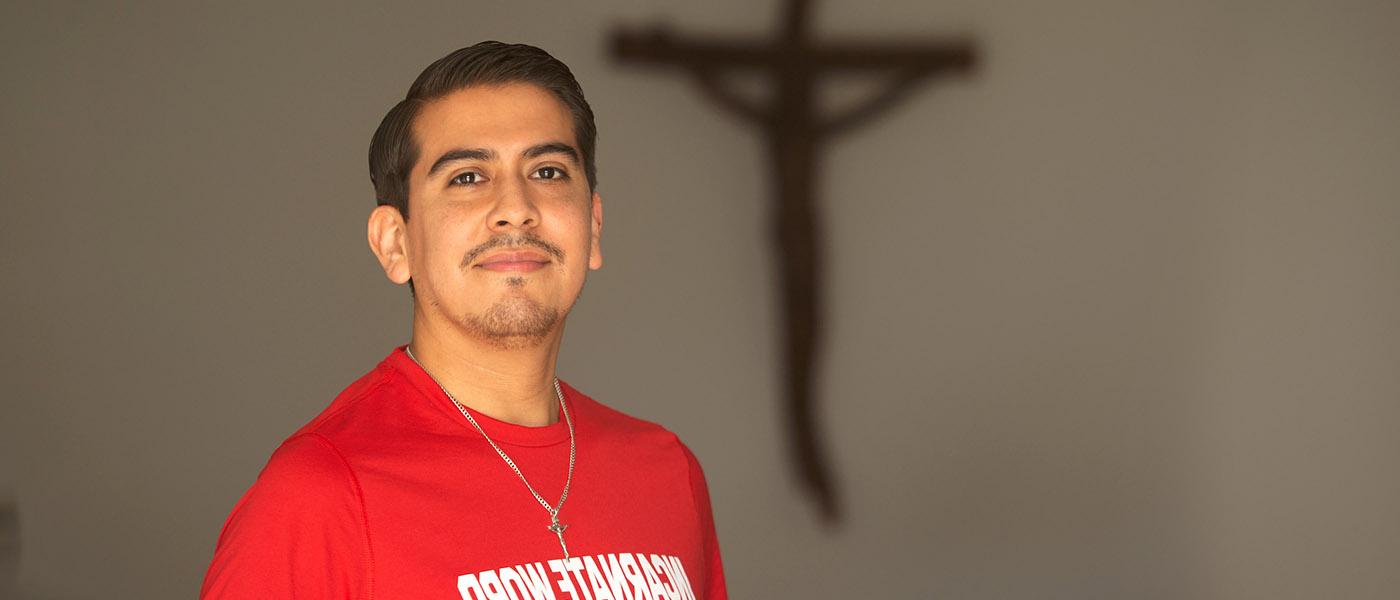 田园研究所 student in a chapel posing in front of a wall with a crucifix on it