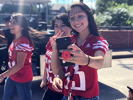 picture of two female students posing for selfie during Flight of th Cardinals walk through tailgate